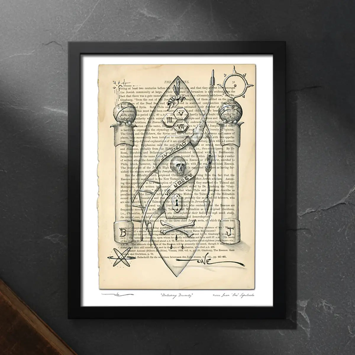 Framed Unlocking Divinity artwork on stone surface with antique book and studio setting